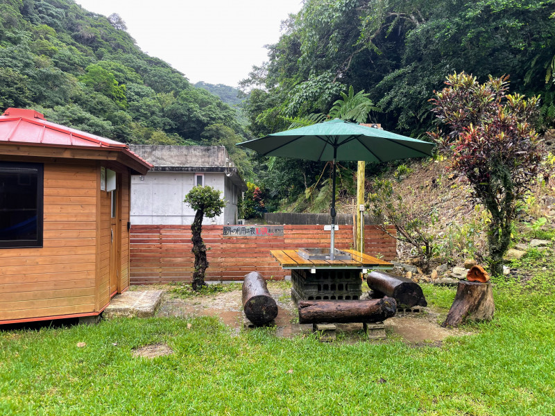 庭のバーベキュー設備と小さな小屋