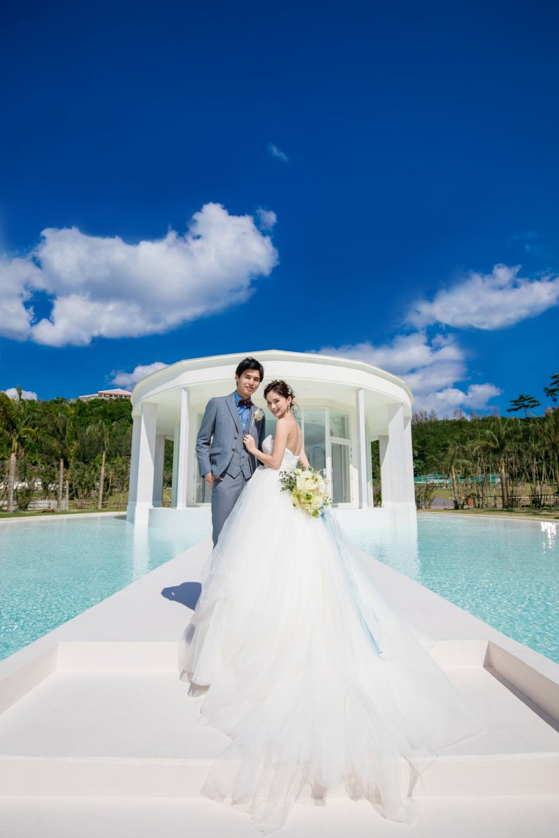 水盤に囲まれたチャペルから、海へと続く階段でゲストからのフラワーシャワー、写真撮影。青い空とのコントラストでドレス姿が映えます。