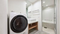 レジデンシャルツインルームのバスルームと洗濯乾燥機。長期滞在に便利です。