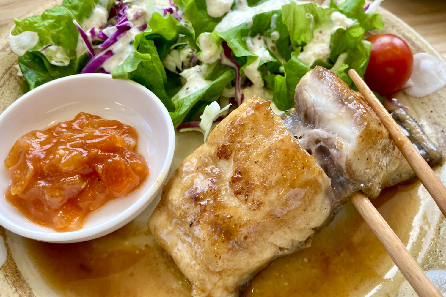 脂の乗ったプリプリな白身をバターしょうゆで焼いています。味変で自家製トマトソースも!