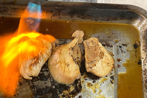 バーナーで炙られる鶏もも肉。香ばしい香りが店内に漂います。